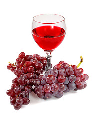 Image showing Glass of red wine and grapes clusters