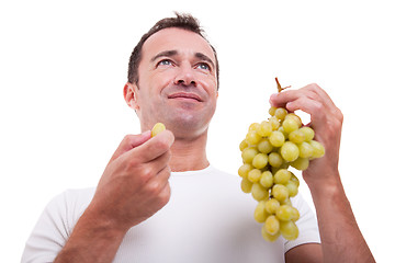 Image showing handsome man eating a green grapes