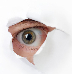 Image showing Eye looking through a hole