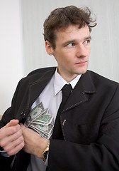 Image showing The man hides money