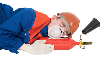 Image showing Sleeping laborer with fire extinguisheron 