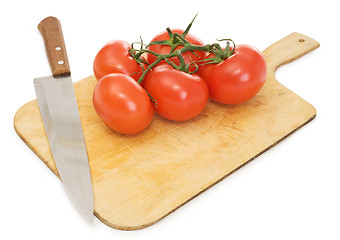 Image showing Red tomatoes and kitchen knife on a chopping board