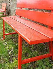 Image showing Red benches in green grass