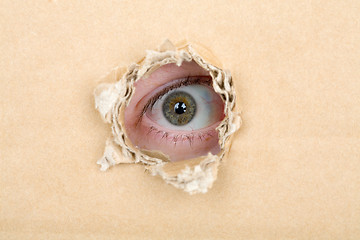 Image showing Eye looking from a hole in a cardboard