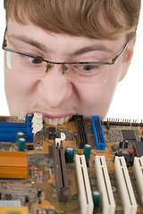 Image showing Guy bites an old circuit board