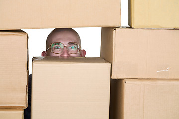 Image showing Man looking through pile of cardboard boxes