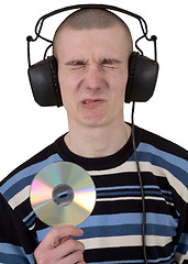 Image showing The young guy with ear-phones and a compact disk