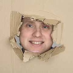 Image showing Male face in hole carton