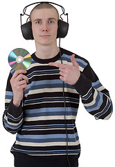 Image showing The young guy with ear-phones and a compact disk