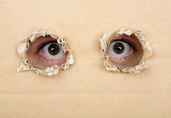 Image showing Eye looking from a holes in a cardboard