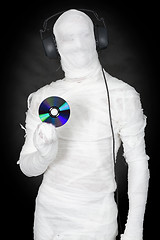 Image showing Man in bandage with ear-phones and disc