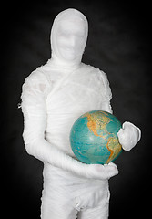 Image showing Man in costume mummy and terrestrial globe