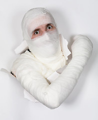 Image showing Boy in bandage put out from hole in paper