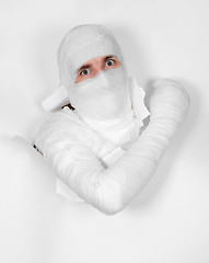 Image showing Boy in bandage put out from hole in paper