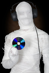 Image showing Man in bandage with ear-phones and disc