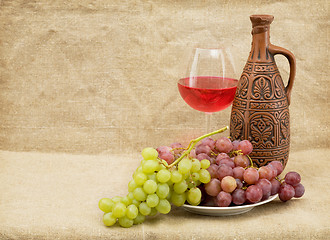 Image showing Ceramic brown bottle, grapes and goblet