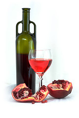 Image showing Glass of wine, bottle and a red pomegranate