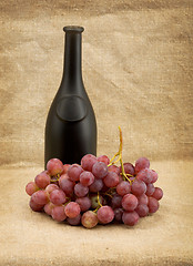 Image showing Dark bottle and red grapes bunch