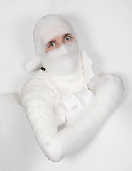 Image showing Boy in bandage put out from hole in paper