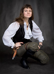 Image showing Girl - pirate with pistol sit on black