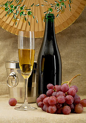 Image showing Champagne bottle, bucket, goblet and grapes