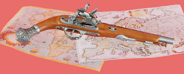 Image showing Ancient pistol on maps background