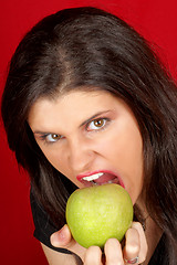 Image showing Angry young woman with green apple