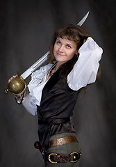 Image showing Pirate - girl with a sabre in hand on a black