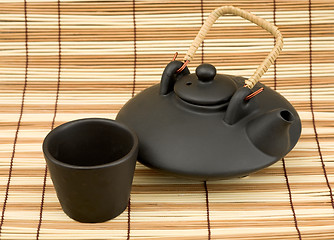 Image showing Black ceramic chinese teapot and mugs