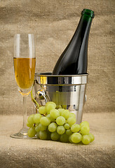 Image showing Champagne bottle, bucket, goblet and grapes