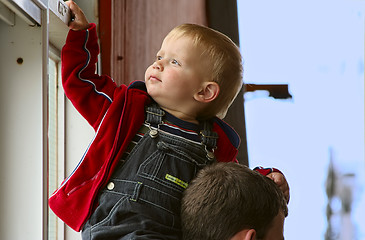 Image showing two year old boy siting on his dad`s  neck.