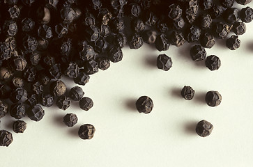 Image showing Whole black peppercorns on white