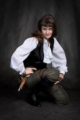 Image showing Girl - pirate with pistol sit on black