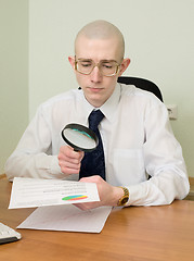 Image showing Boss with a magnifier on a workplace