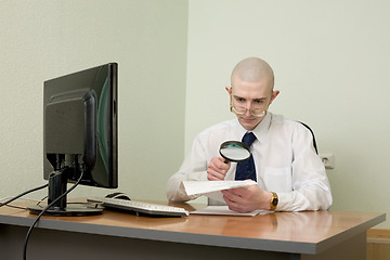 Image showing Boss with a magnifier on a workplace