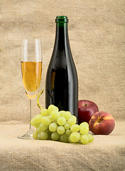 Image showing Champagne bottle, goblet, grapes, apple and peach
