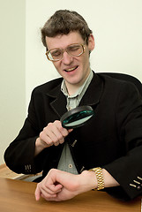 Image showing Person view a watch through a magnifier