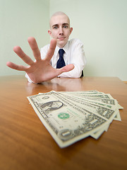 Image showing Man reaches for a batch of money