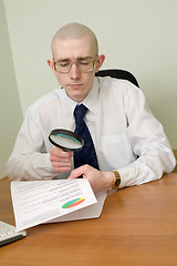 Image showing Boss with a magnifier on a workplace