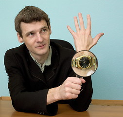 Image showing Person view a watch through a magnifier
