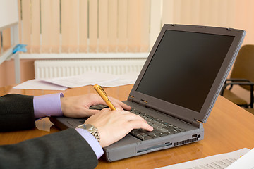 Image showing Laptop and hands with a pen