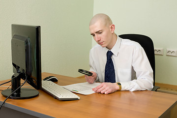 Image showing Businessman with a magnifier on a workplace