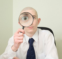 Image showing Guy looks through the big magnifier