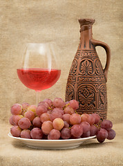 Image showing Ceramic bottle, goblet and grapes