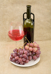 Image showing Still-life with a glass of red wine, bottle and grapes