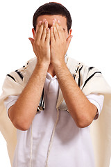 Image showing jewish man closing face with his hands while praying