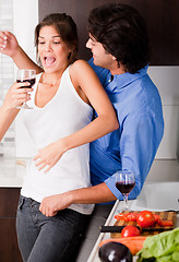 Image showing playful young couple enjoying their love in kitchen