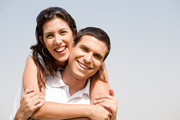 Image showing Happy young guy piggybacking his girlfriend