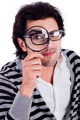 Image showing young man looking stright with a magnifying glass