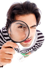 Image showing young man looking up with a magnifying glass